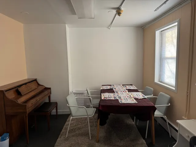 Dining space featuring baseboard heating and dark colored carpet