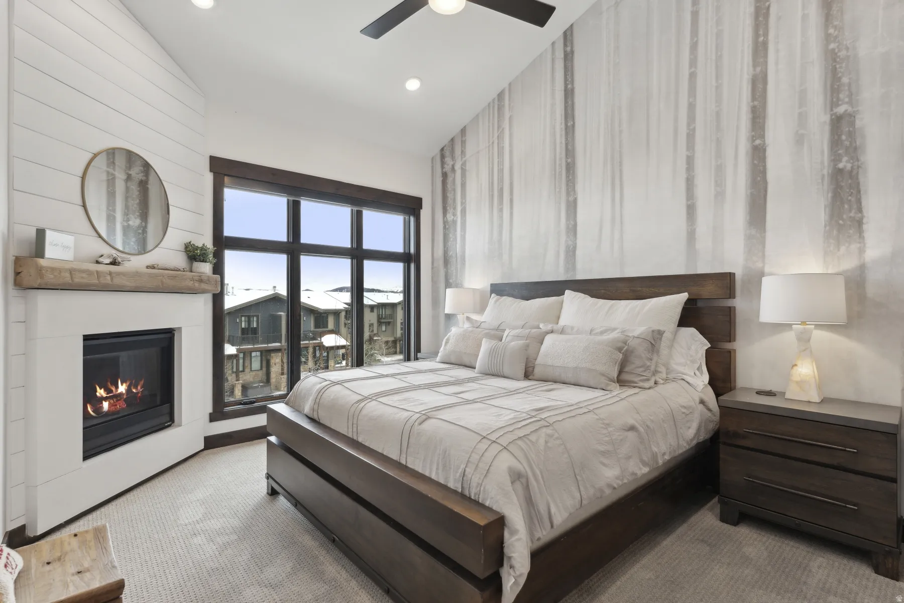 Carpeted bedroom featuring a glass covered fireplace, a ceiling fan, recessed lighting, and wood walls