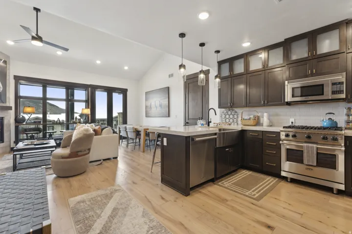 Kitchen featuring a kitchen bar, dark brown cabinetry, open floor plan, a peninsula, and appliances with stainless steel finishes