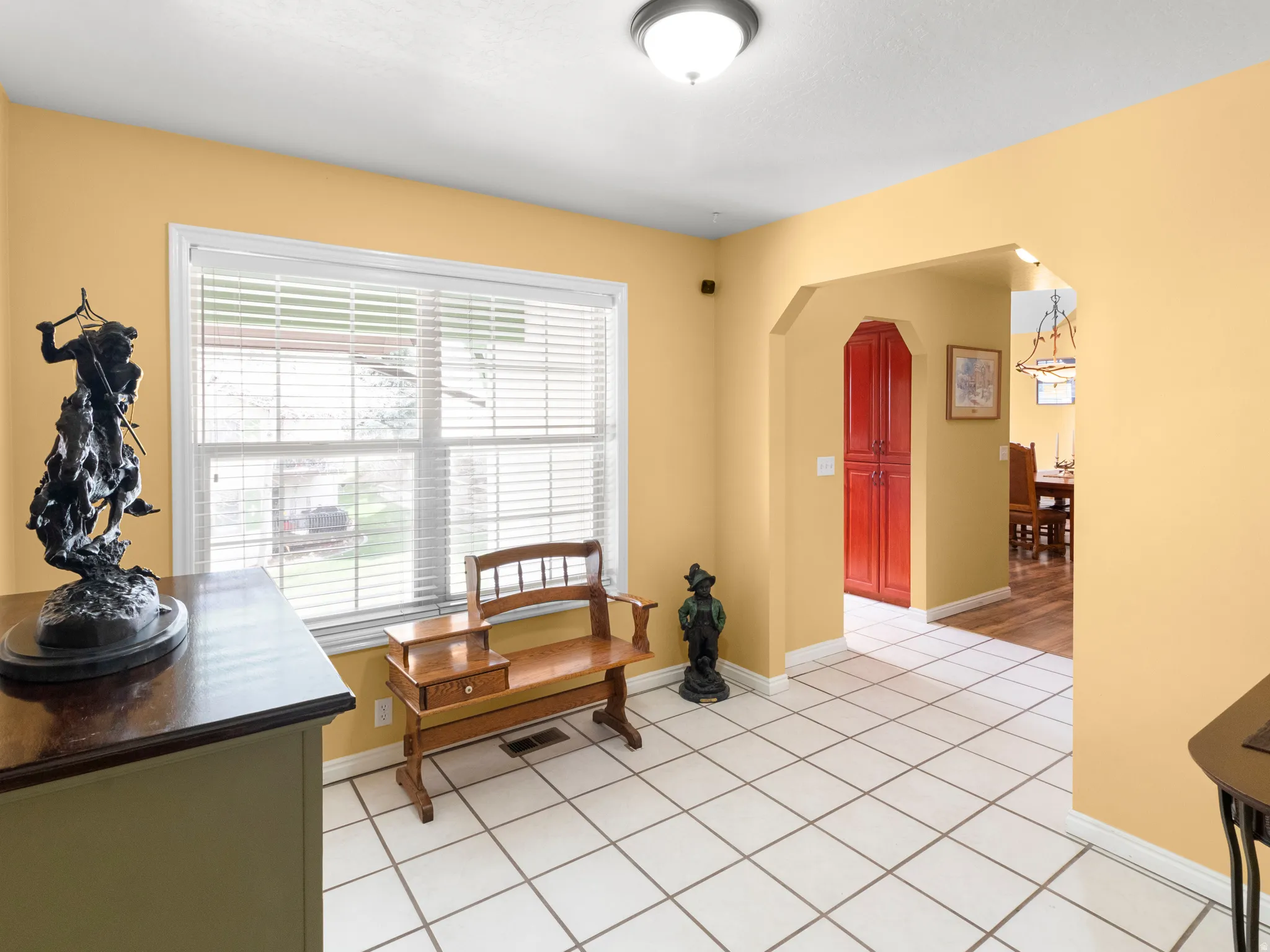 Living area featuring arched walkways and light tile patterned floors