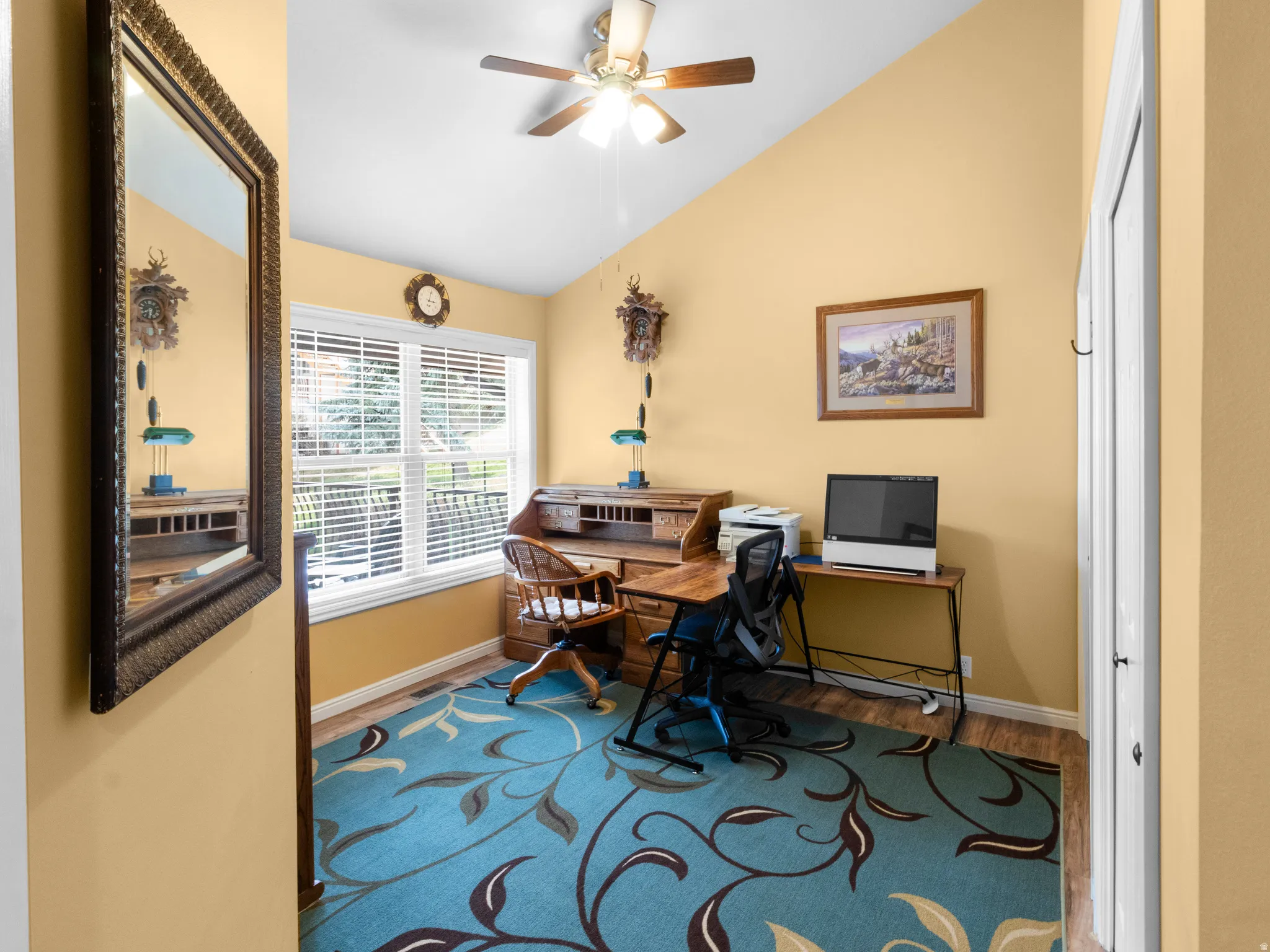 Home office featuring lofted ceiling, wood finished floors, and ceiling fan