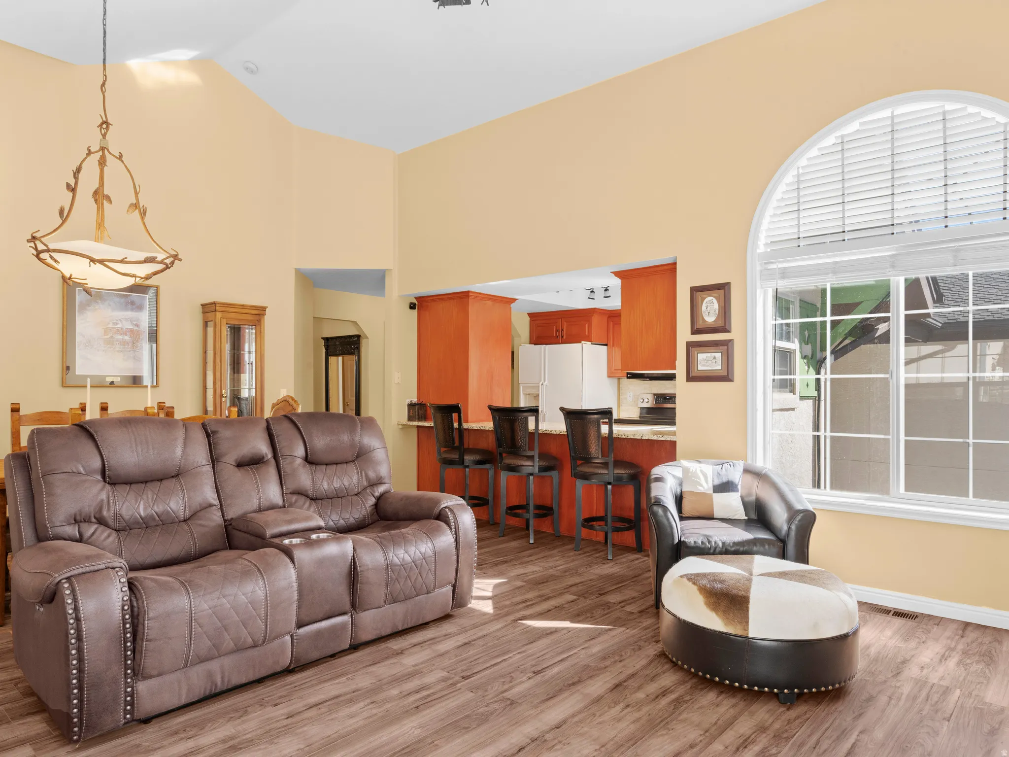 Living room with light wood-type flooring and high vaulted ceiling