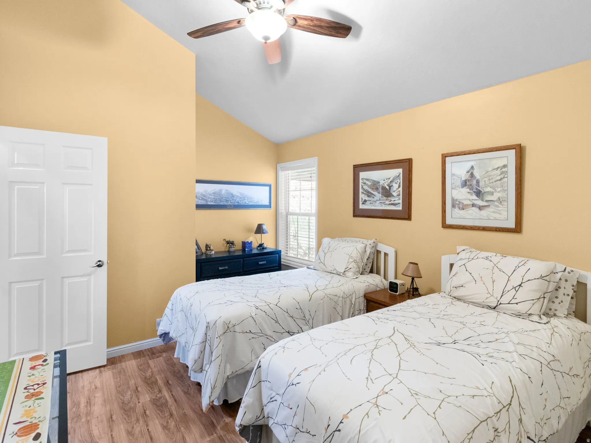 Bedroom featuring vaulted ceiling, wood finished floors, and a ceiling fan