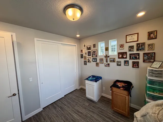 Bedroom featuring a closet, dark wood-type flooring, recessed lighting, and a textured ceiling