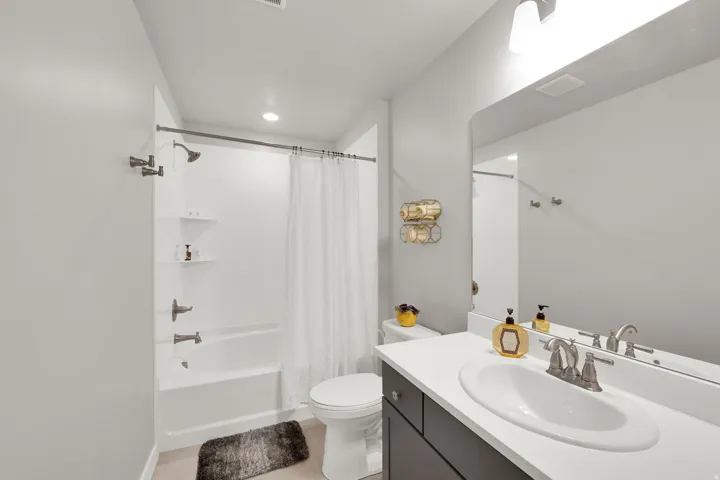 Full bath featuring shower / tub combo with curtain, vanity, and light tile patterned flooring