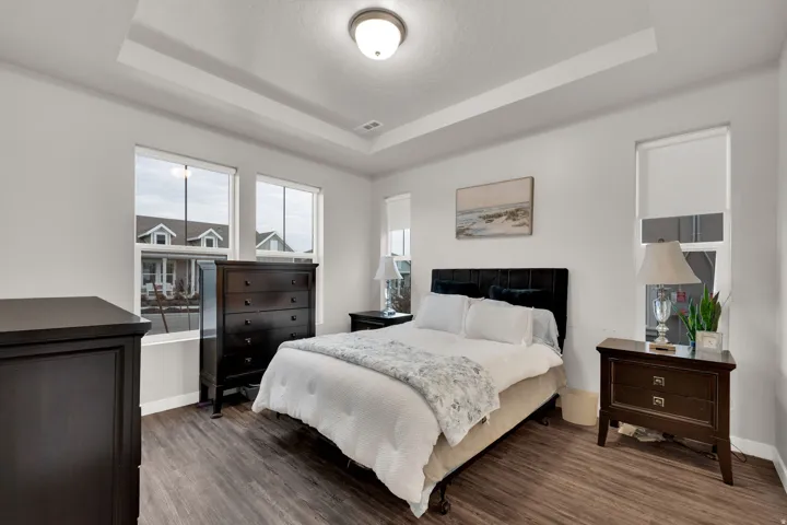 Bedroom featuring a raised ceiling and wood finished floors