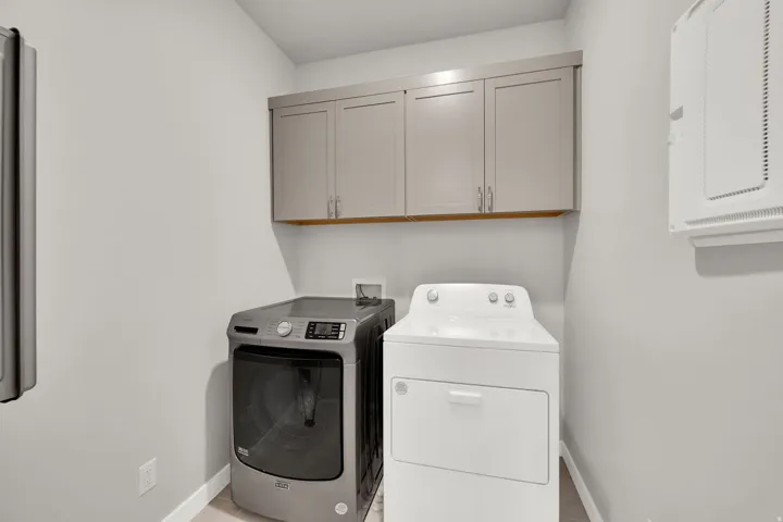 Washroom featuring cabinet space and washer and clothes dryer