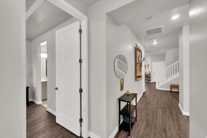 Hall featuring dark wood-type flooring, recessed lighting, and stairs