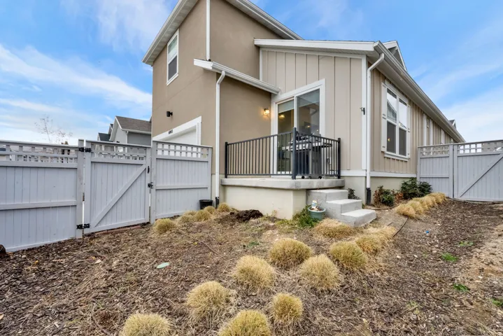 View of home's exterior featuring a gate, a deck, and board and batten siding