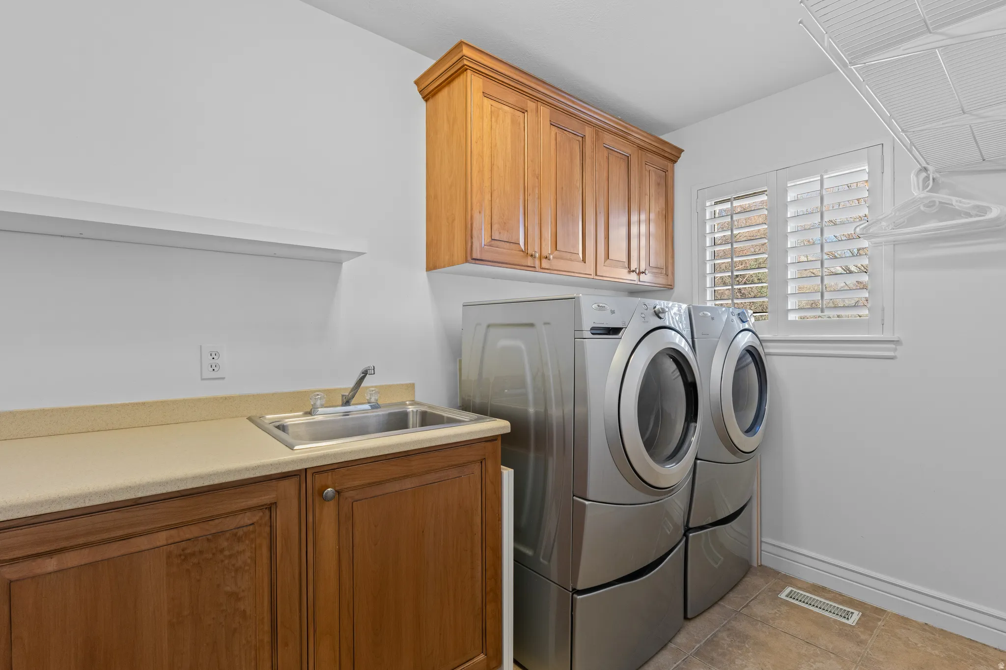 Laundry room featuring cabinet space, washer and clothes dryer, and light tile patterned floors