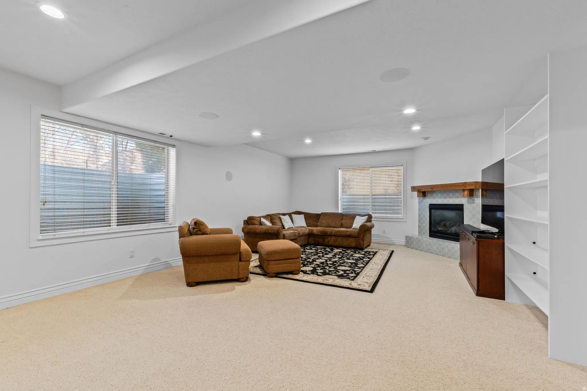 Living area featuring recessed lighting, a tile fireplace, light carpet, and plenty of natural light