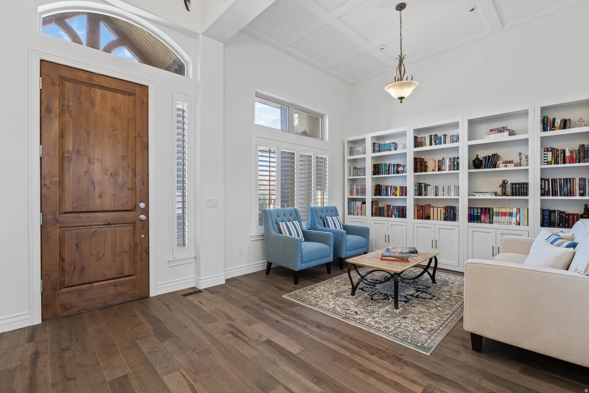 Foyer featuring a high ceiling, healthy amount of natural light, dark wood-style flooring, and coffered ceiling