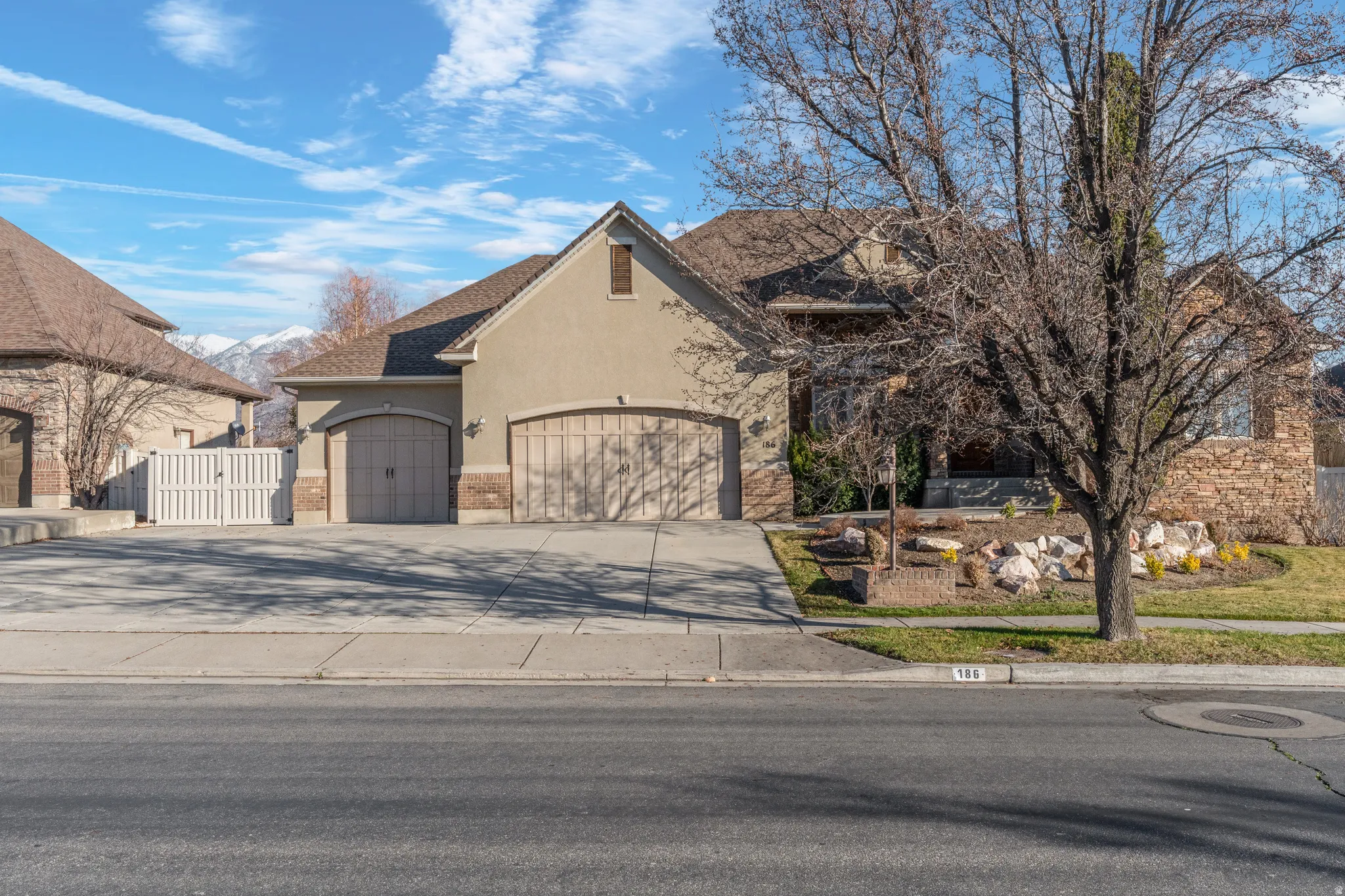 View of front facade with stucco siding, concrete driveway, and a garage
