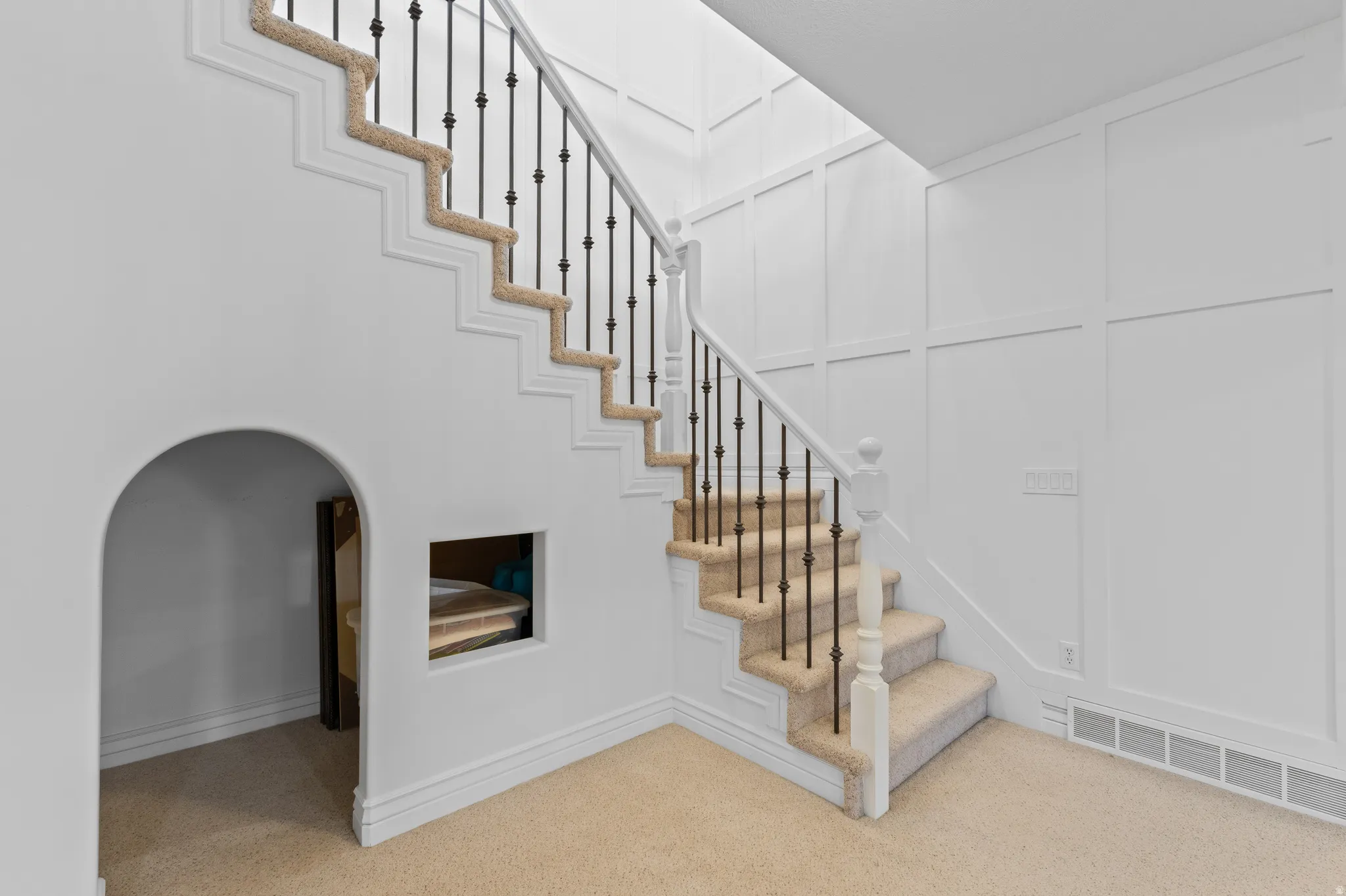 Stairs featuring a decorative wall and carpet floors