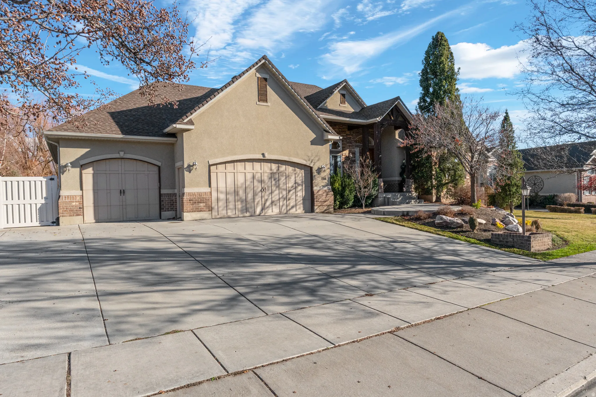 View of front facade featuring stucco siding, an attached garage, and driveway