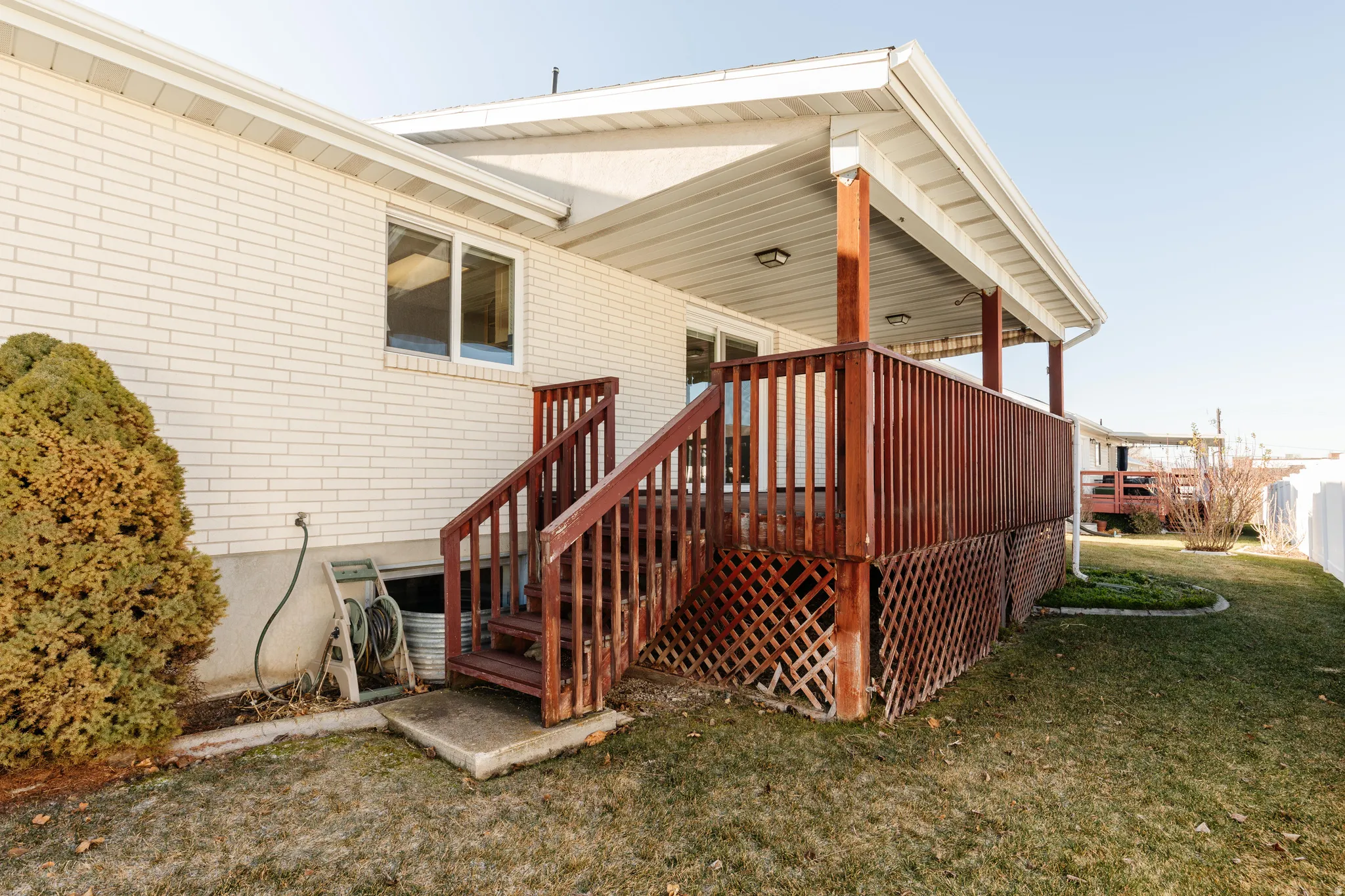 Wooden terrace featuring a yard and stairs