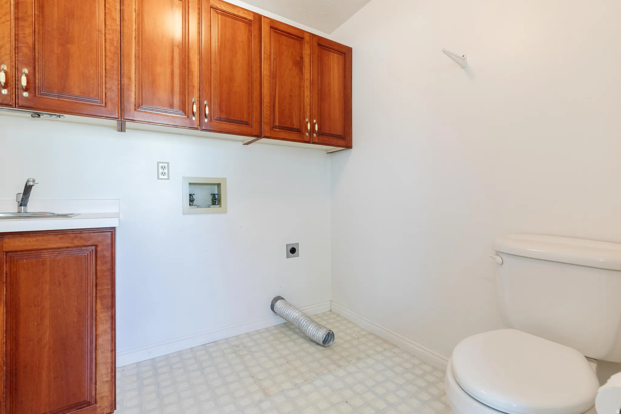 Washroom featuring light flooring, hookup for a washing machine, and electric dryer hookup