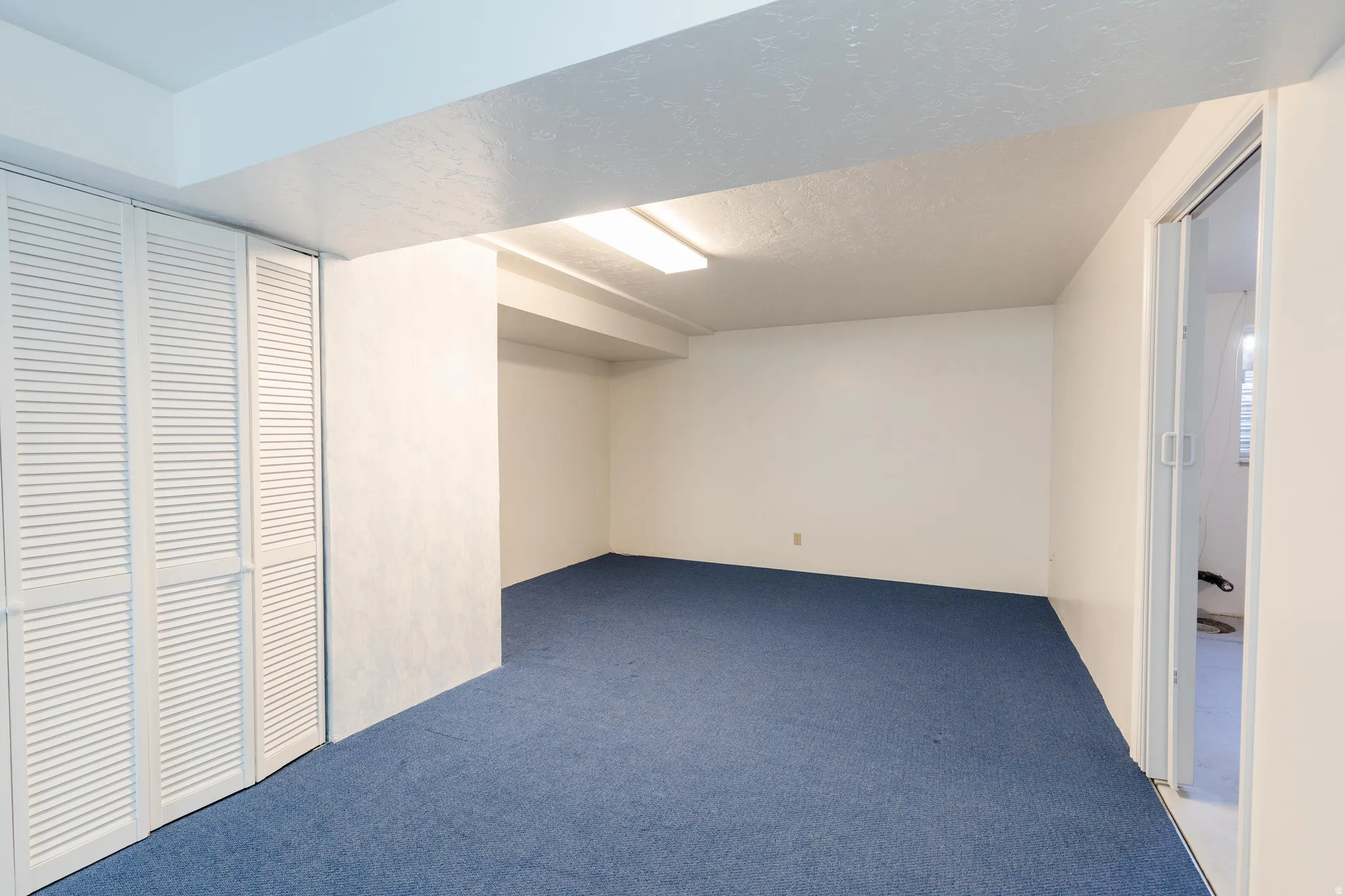Finished below grade area featuring carpet and a textured ceiling