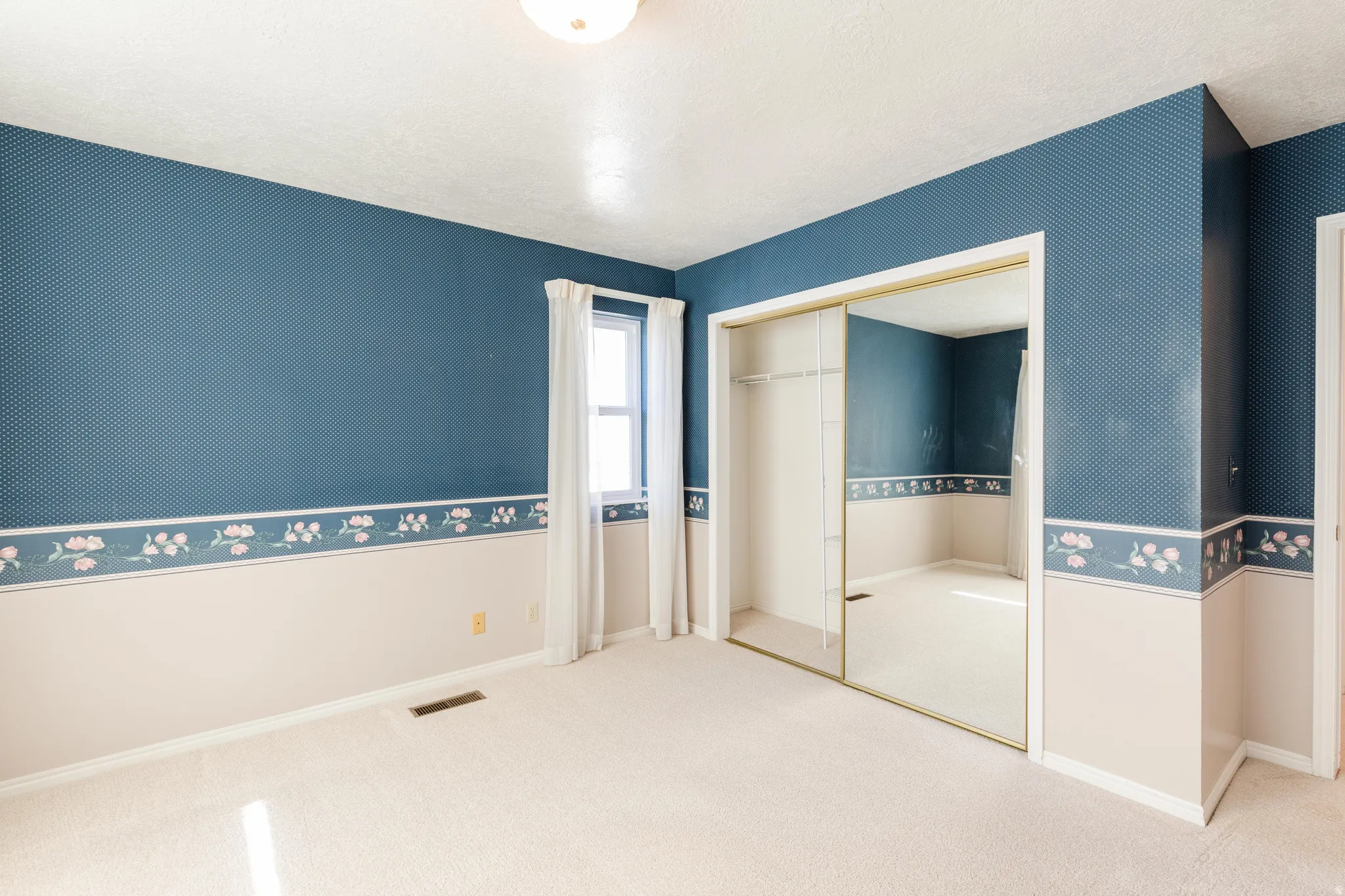 Unfurnished bedroom with carpet flooring, a textured ceiling, and a closet