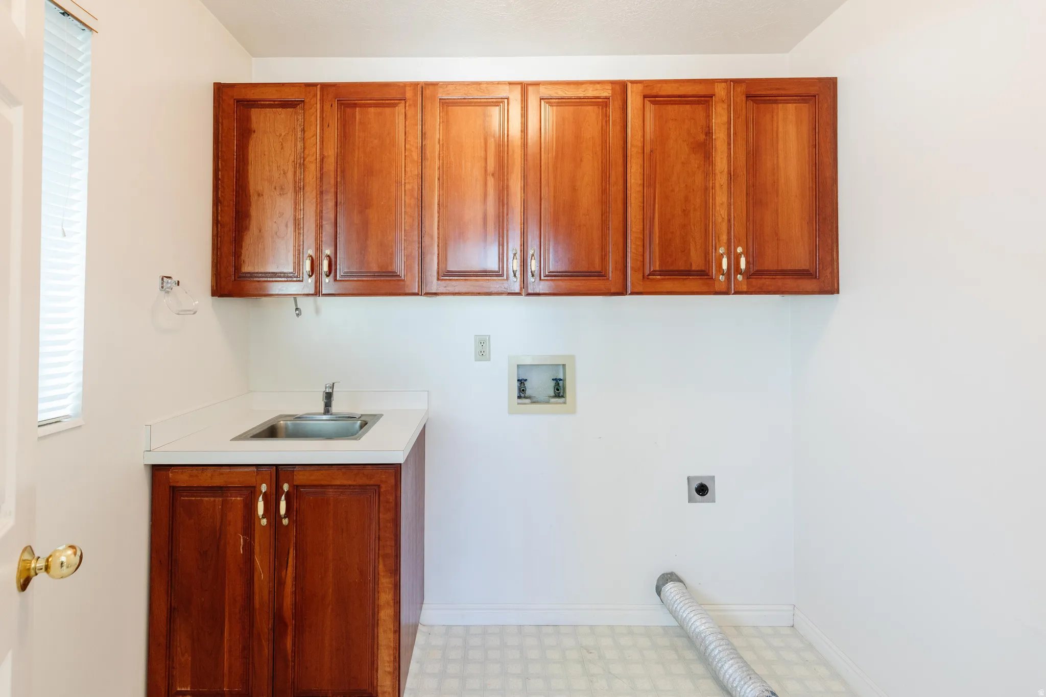 Laundry area featuring light floors, hookup for a washing machine, cabinet space, and electric dryer hookup