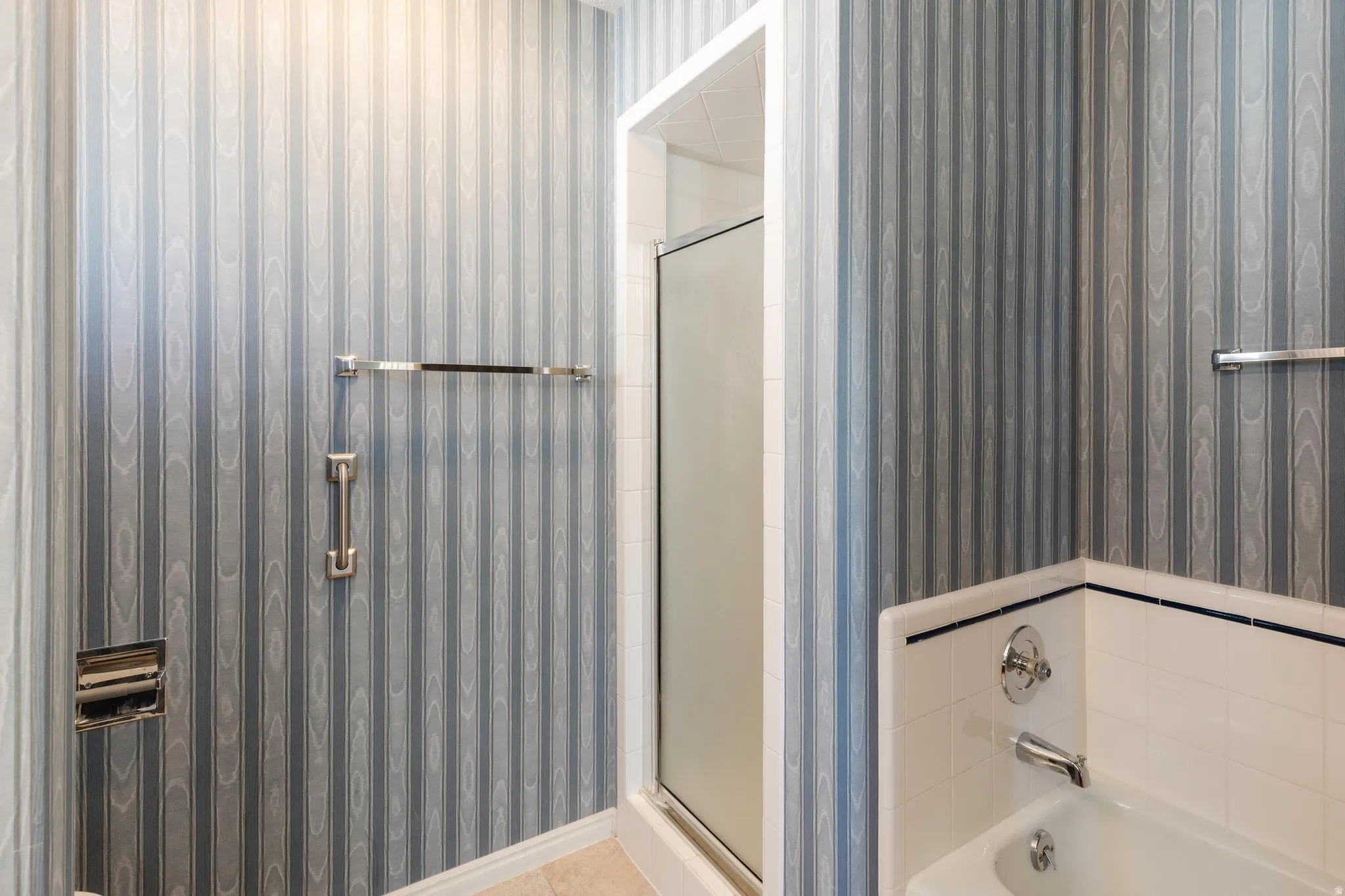 Bathroom featuring wallpapered walls, a shower stall, and a bath
