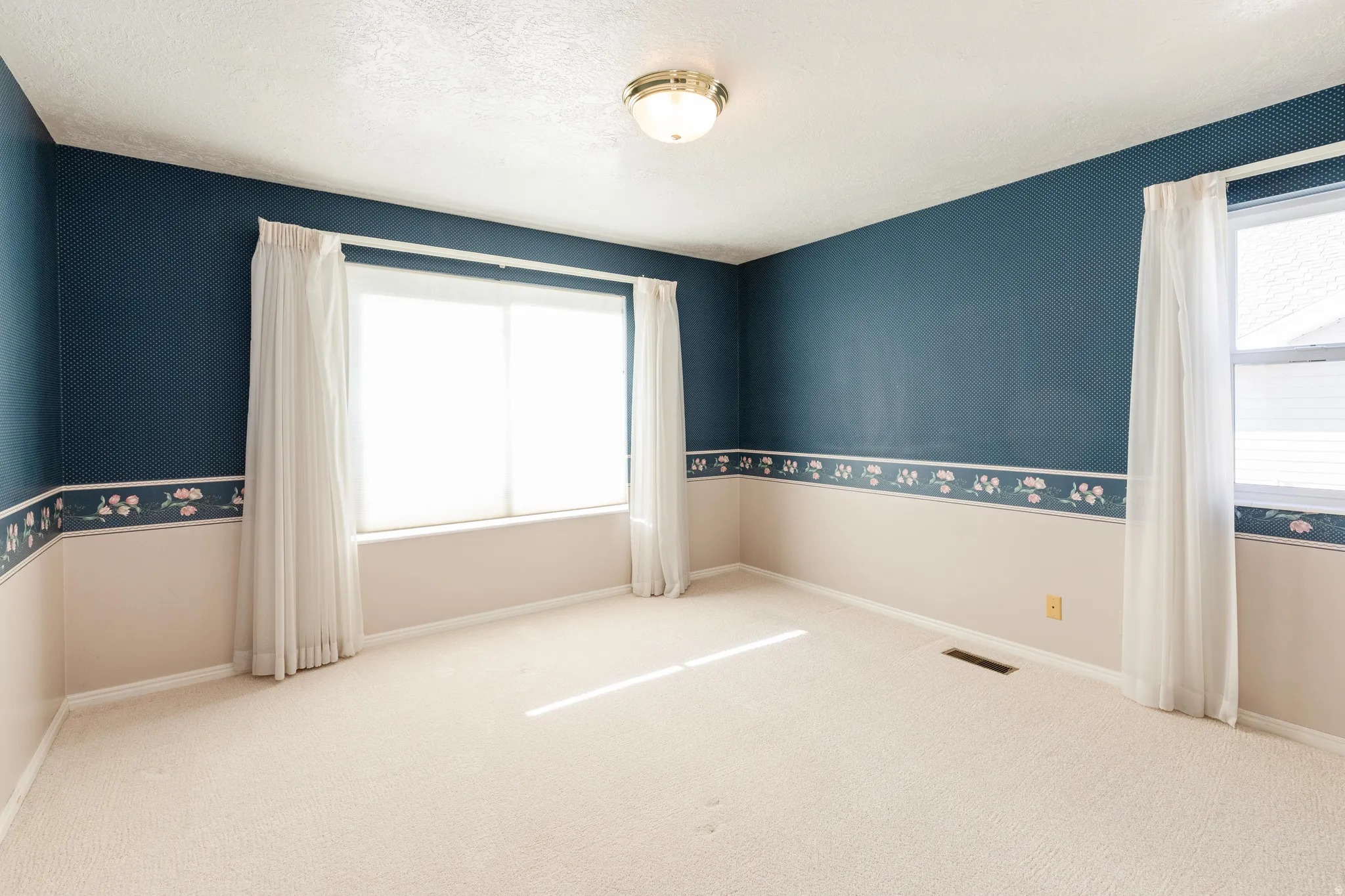 Empty room with carpet flooring and a textured ceiling