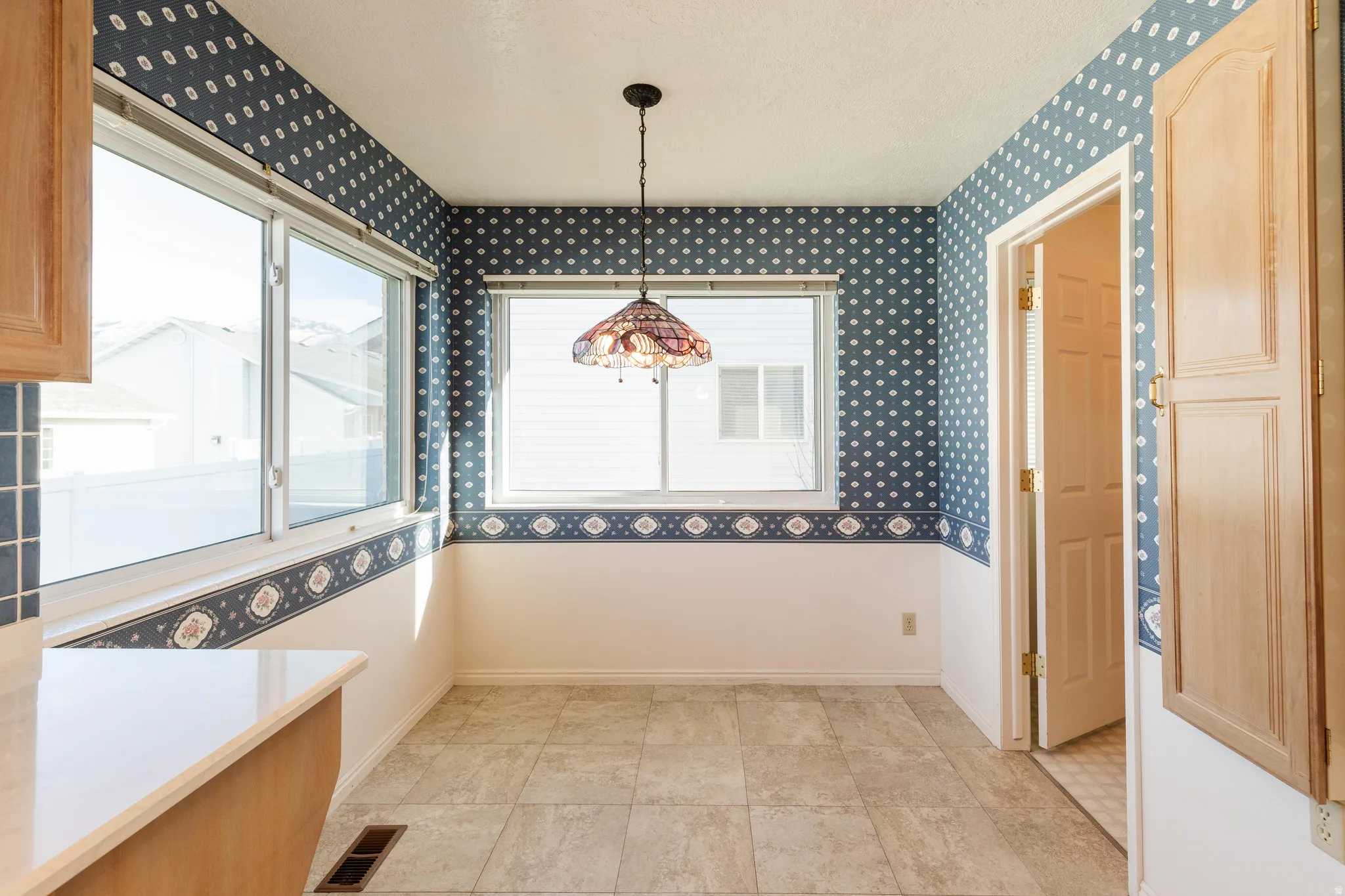 Unfurnished dining area featuring plenty of natural light and wallpapered walls
