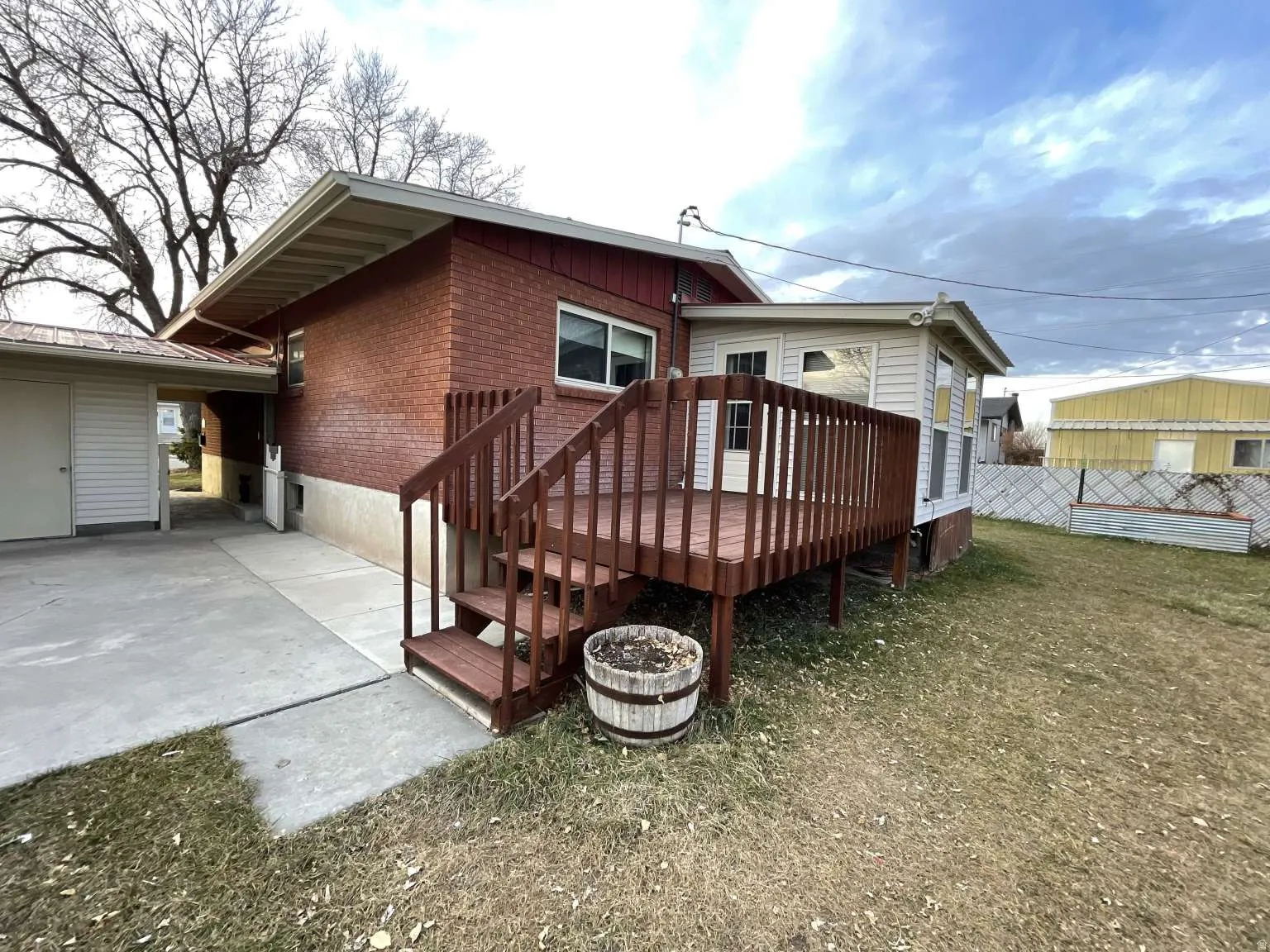Back of house featuring a deck, brick siding, and a patio