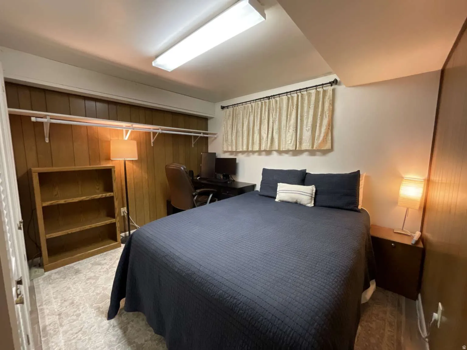Bedroom featuring wood walls and a closet