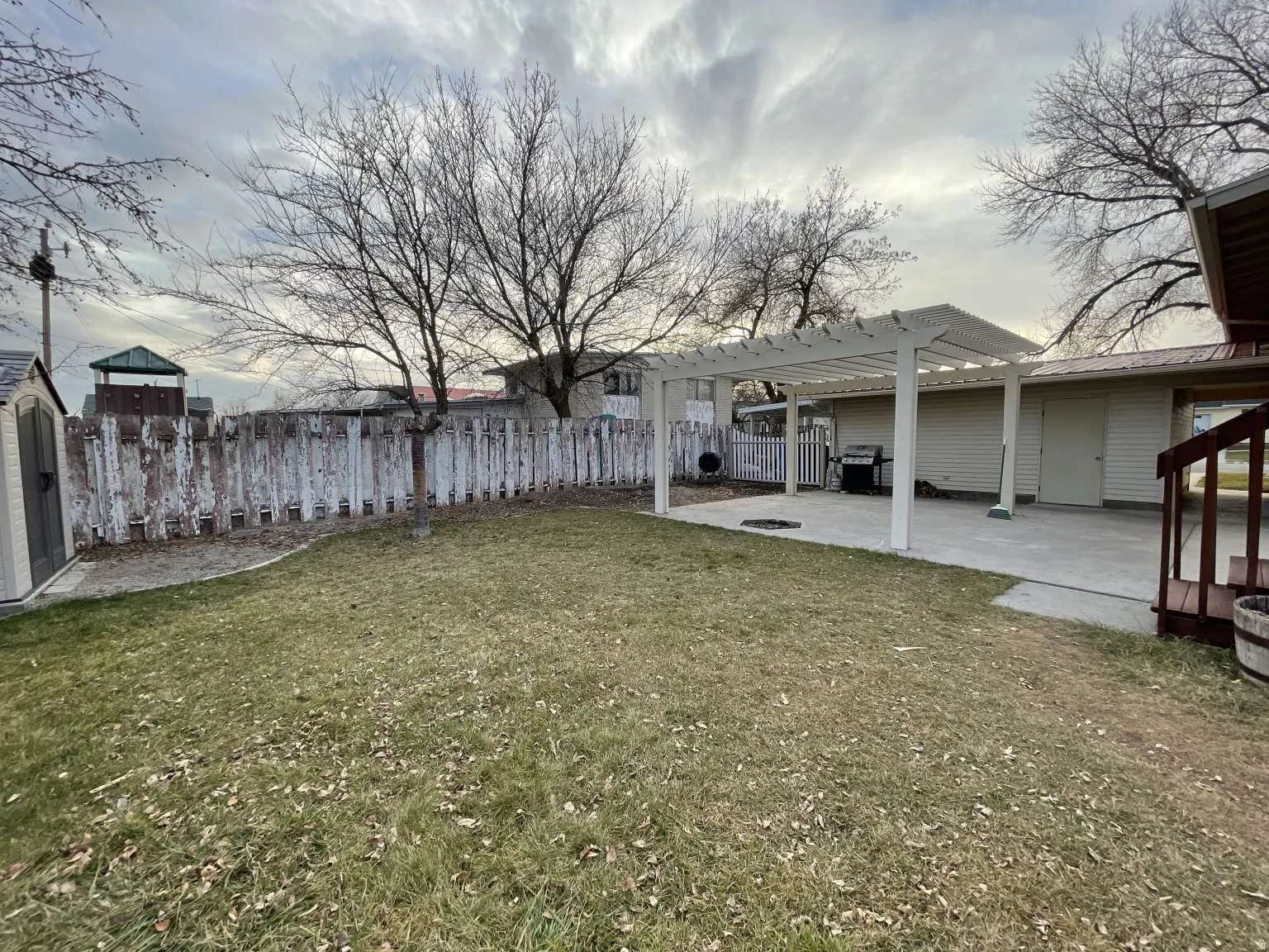 Fenced backyard featuring a patio area and a pergola