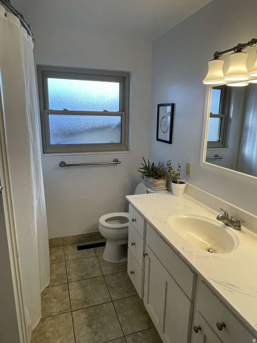 Full bathroom featuring vanity, a shower with curtain, and light tile patterned flooring