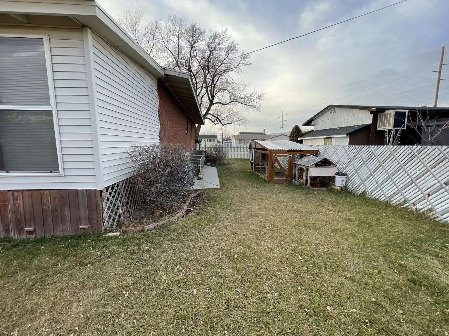 Fenced backyard featuring an outdoor structure, exterior structure, and an AC wall unit