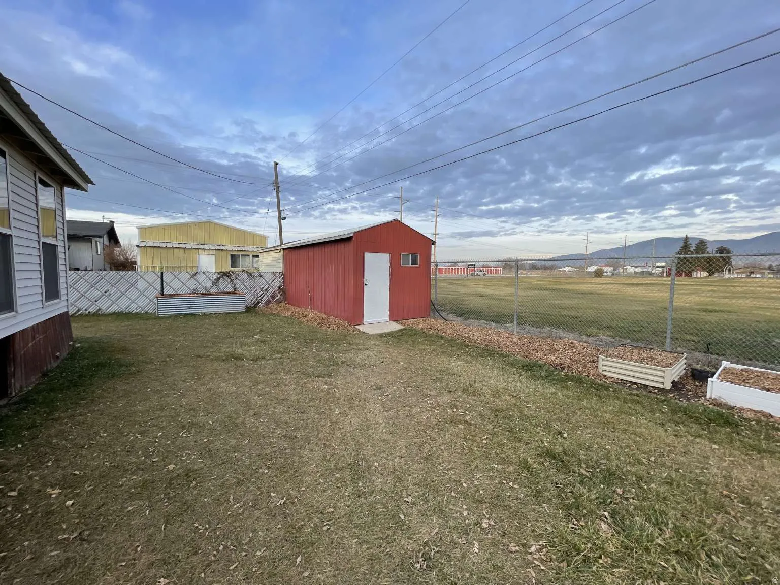 Fenced backyard featuring a storage unit and a mountain view