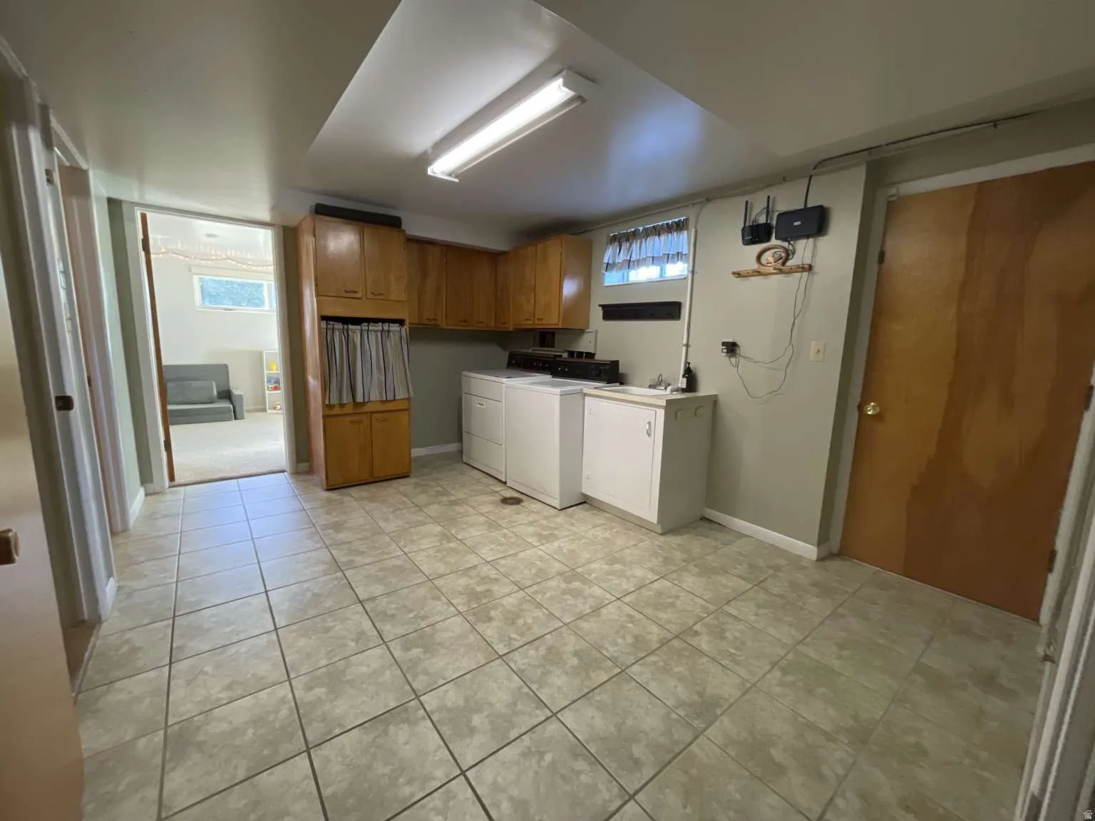 Washroom with light tile patterned floors, cabinet space, and washer and dryer