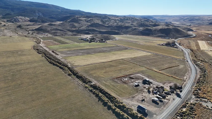 Aerial overview of property's location featuring rural landscape, abundant farmland, and a mountain backdrop
