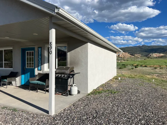 View of property exterior featuring stucco siding, a mountain view, and a porch