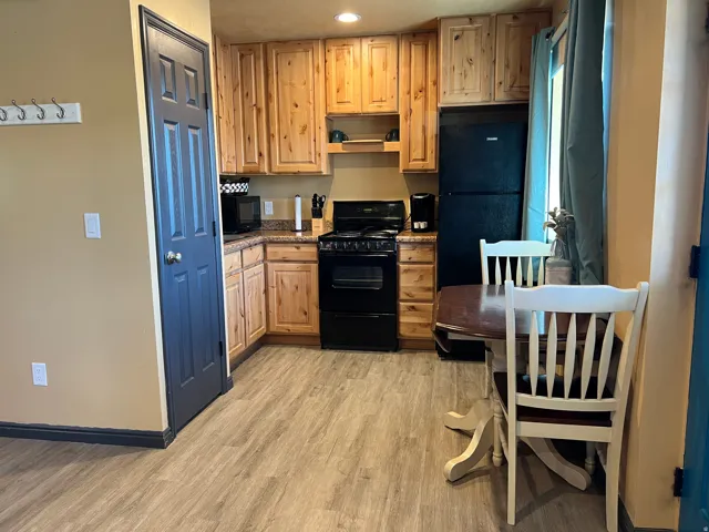 Kitchen featuring black appliances, light wood-style flooring, light brown cabinets, and recessed lighting