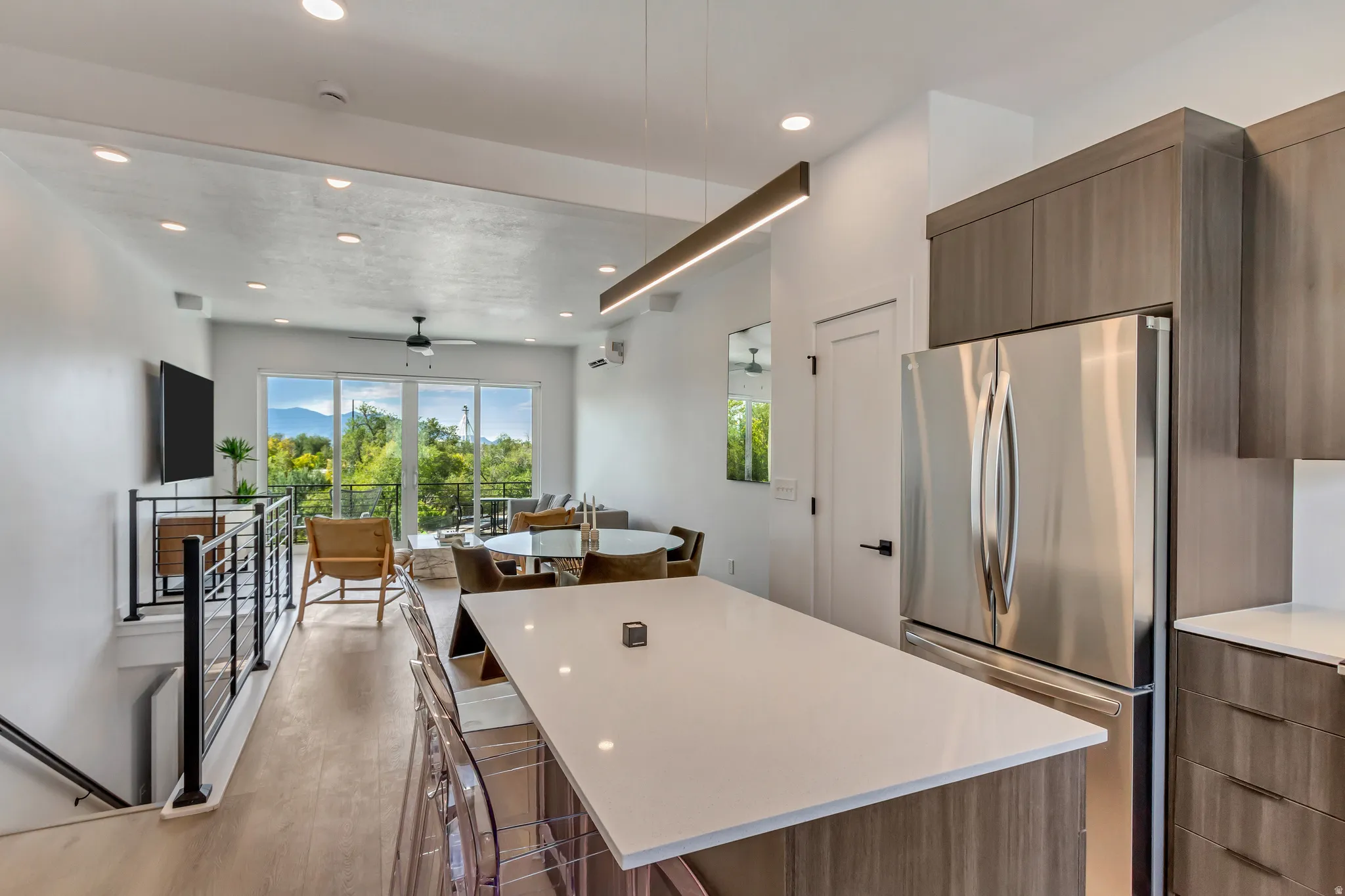 Kitchen featuring freestanding refrigerator, modern cabinets, open floor plan, a kitchen island, and a breakfast bar area