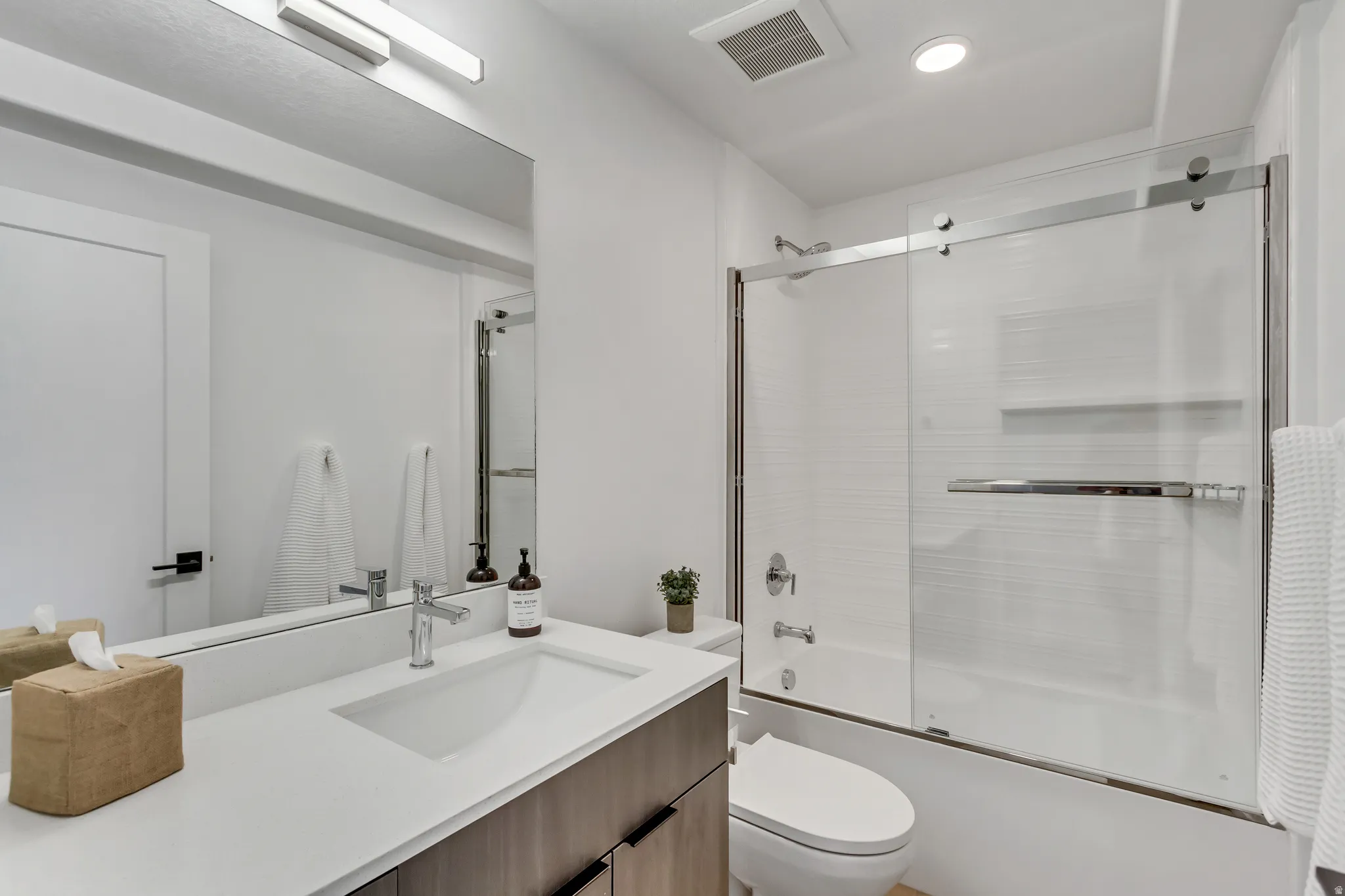 Full bath with vanity and bath / shower combo with glass door