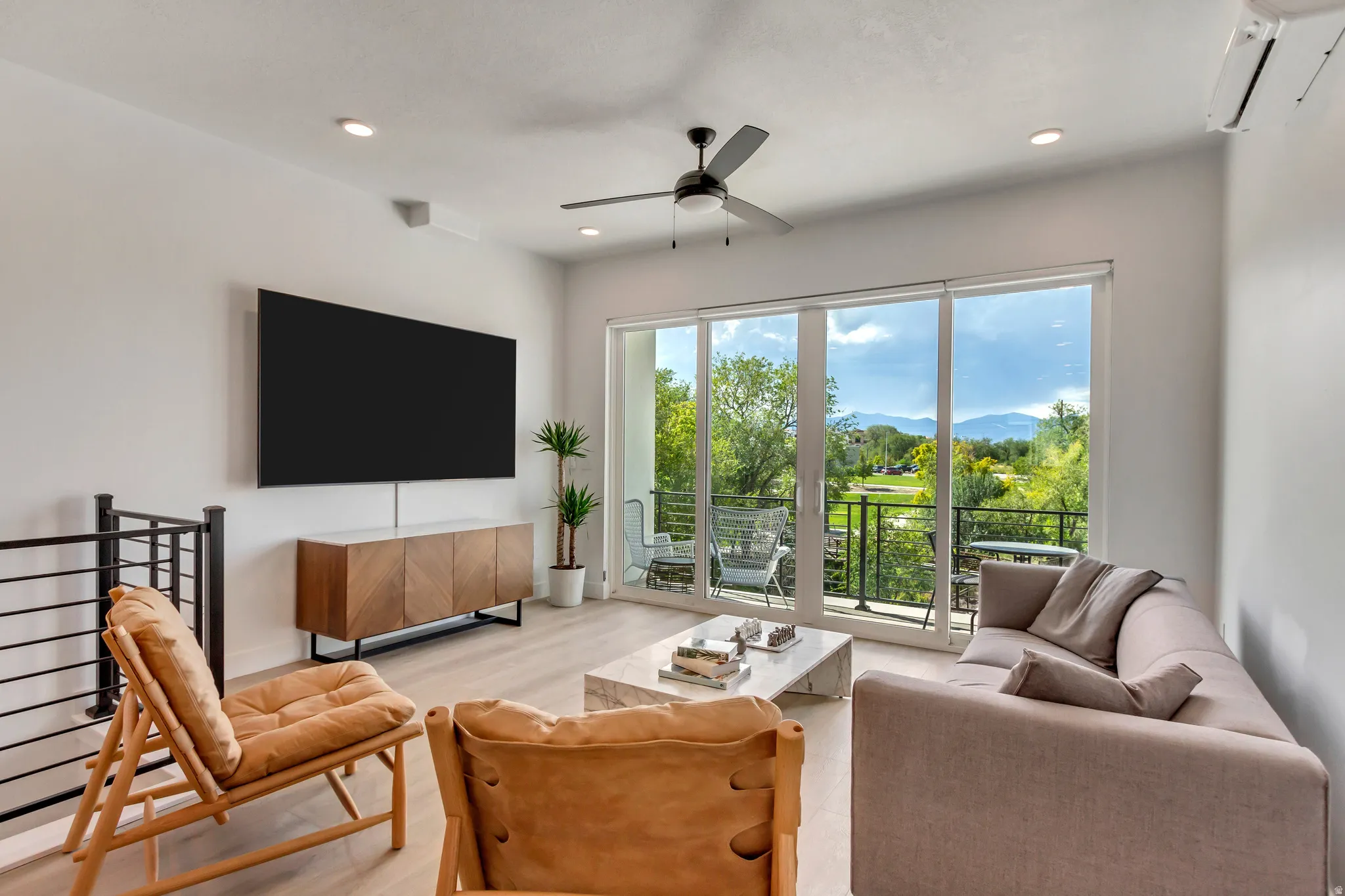 Living room with a wall unit AC, light wood-style flooring, ceiling fan, and recessed lighting