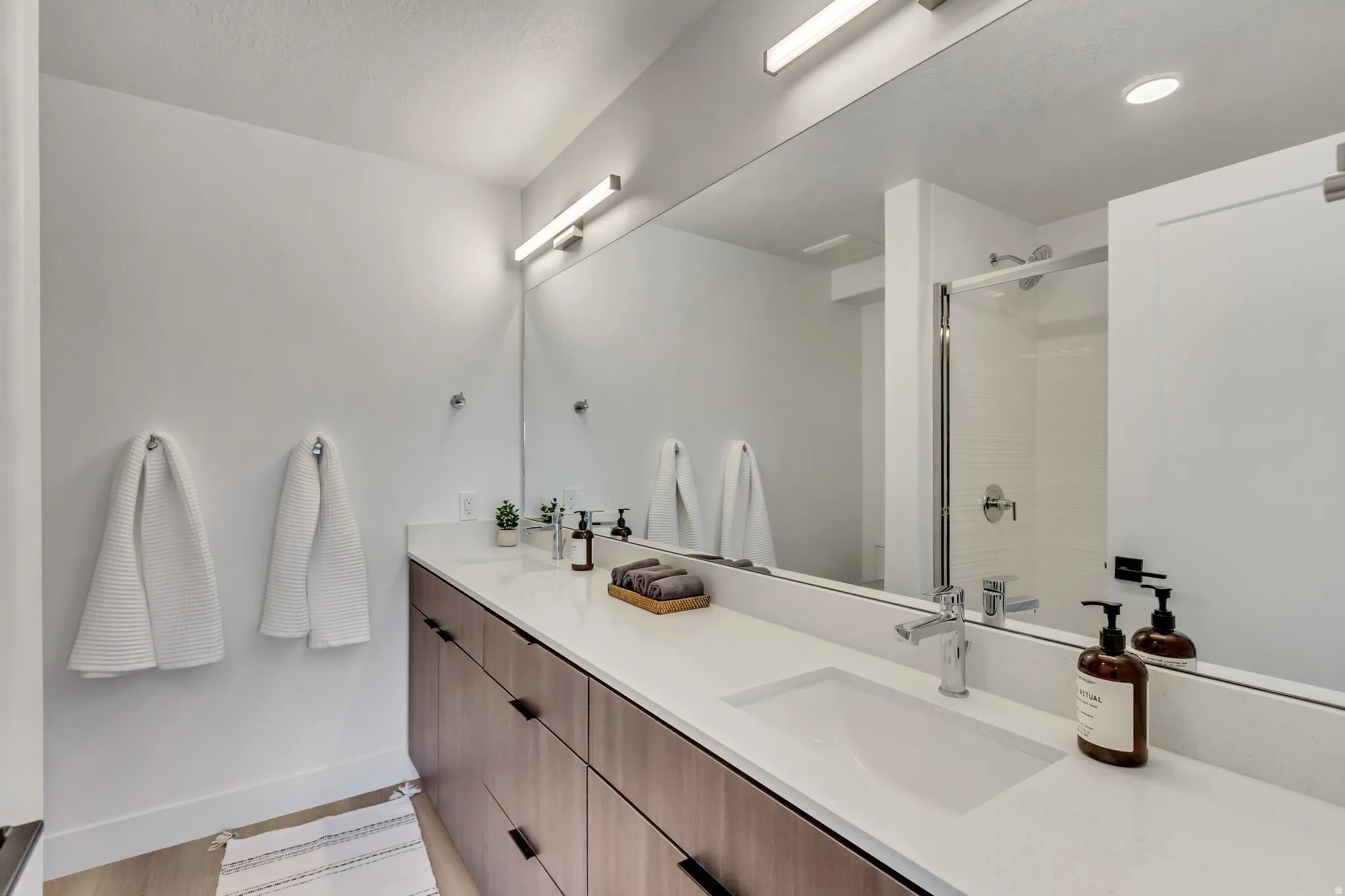 Bathroom featuring double vanity and a shower stall