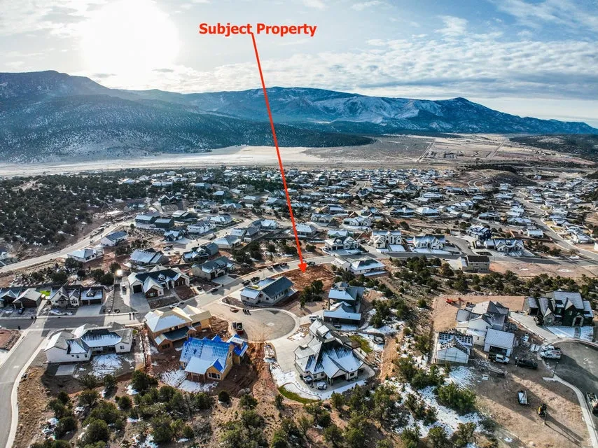 Aerial view of property's location featuring nearby suburban area and mountains