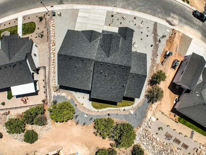 Contemporary residence featuring a dark shingle roof and a gravel perimeter