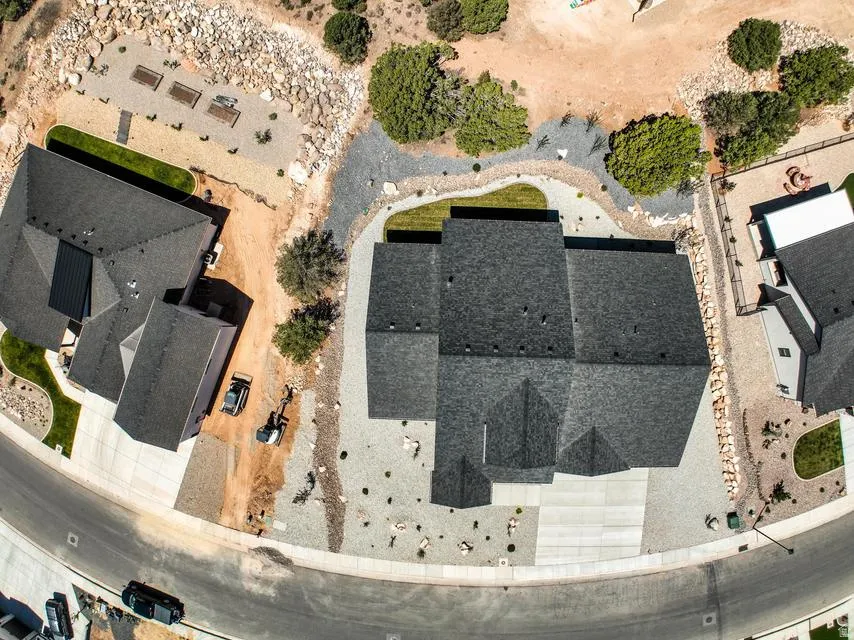 Aerial property view showcasing a large residential structure with a multi-pitched dark shingle roof