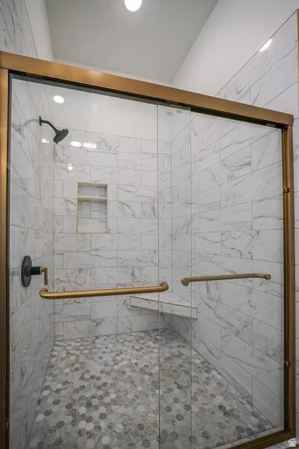 Glass-enclosed shower with bronze-finish framing