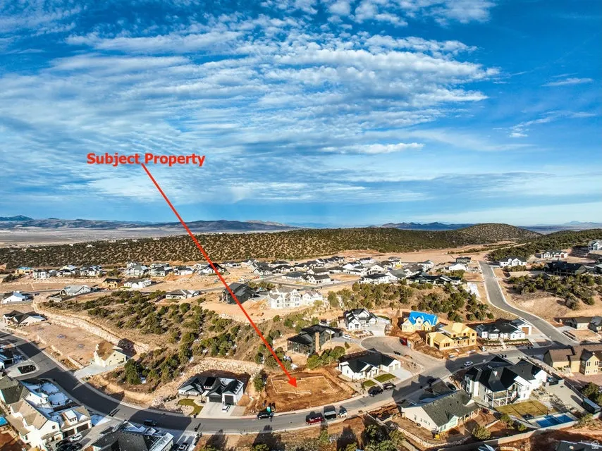 Aerial view of property and surrounding area featuring a mountain backdrop and nearby suburban area