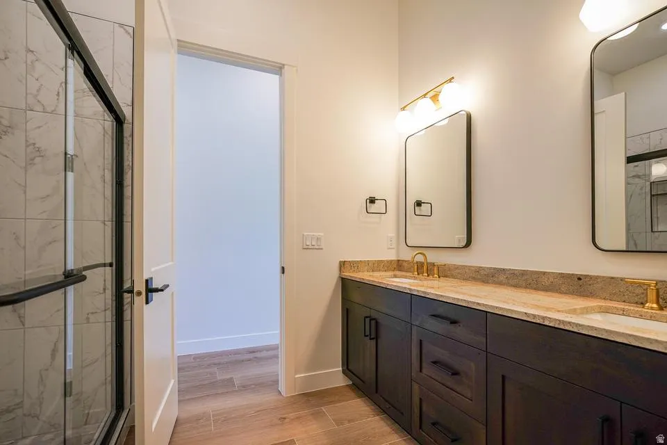 Dual vanity featuring undermount sinks, gold-finish faucets, and black hardware