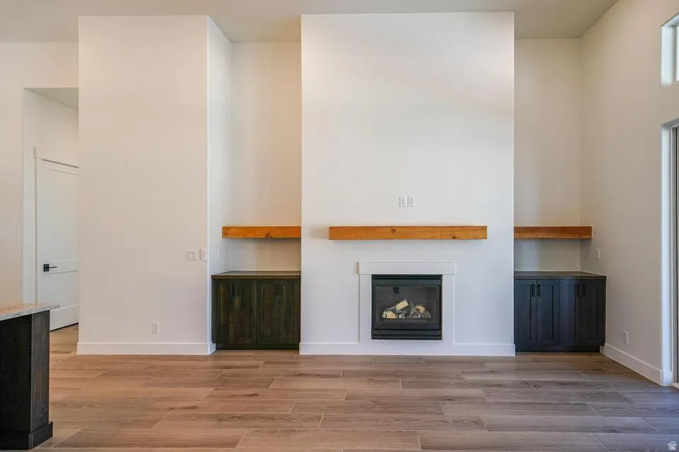 Living area featuring a gas fireplace with a white surround and a wood mantel
