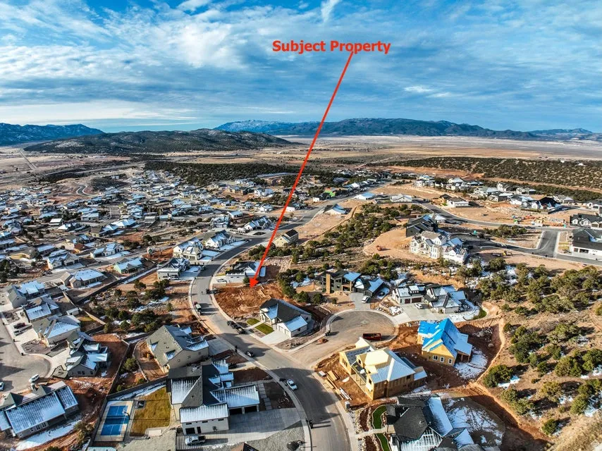 Aerial view of property's location featuring nearby suburban area and a mountainous background