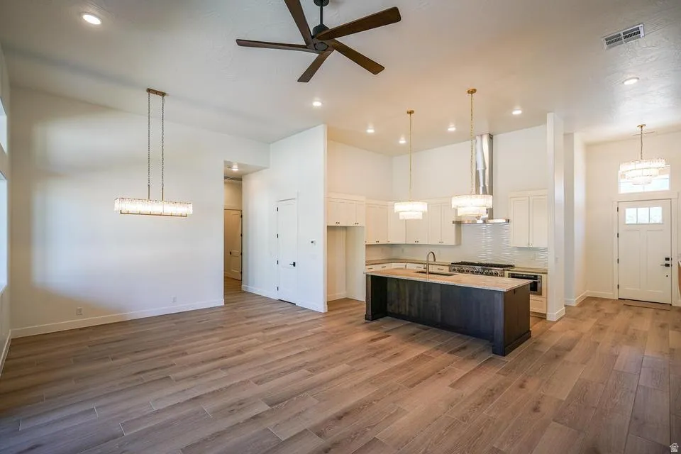 Open-concept living space featuring wood-finish flooring, recessed lighting, and a modern ceiling fan